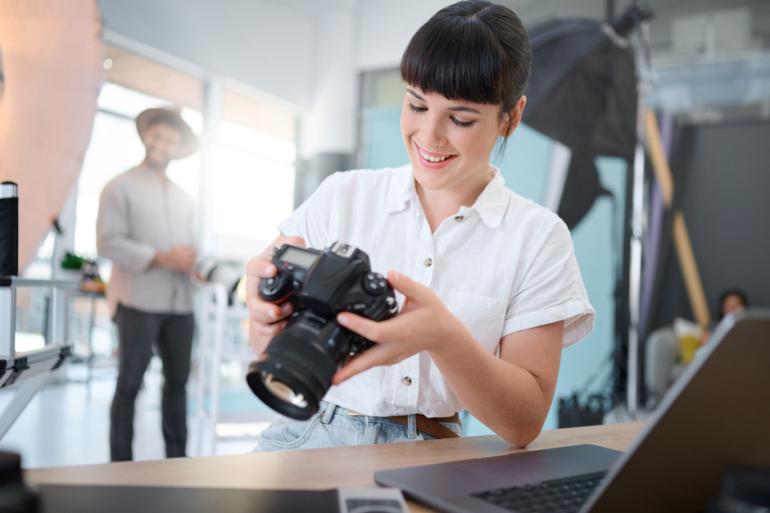 Mujer revisando una cámara profesional